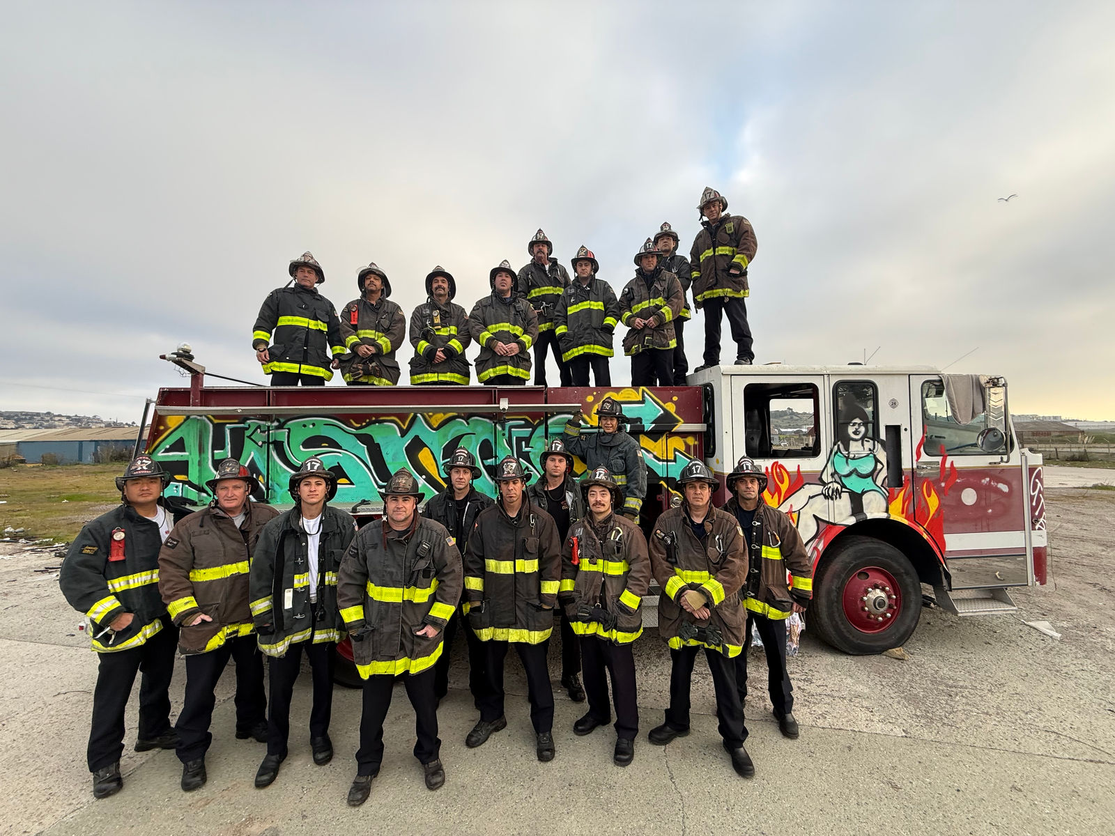 A full company in turnouts posed on and around their engine at the coast