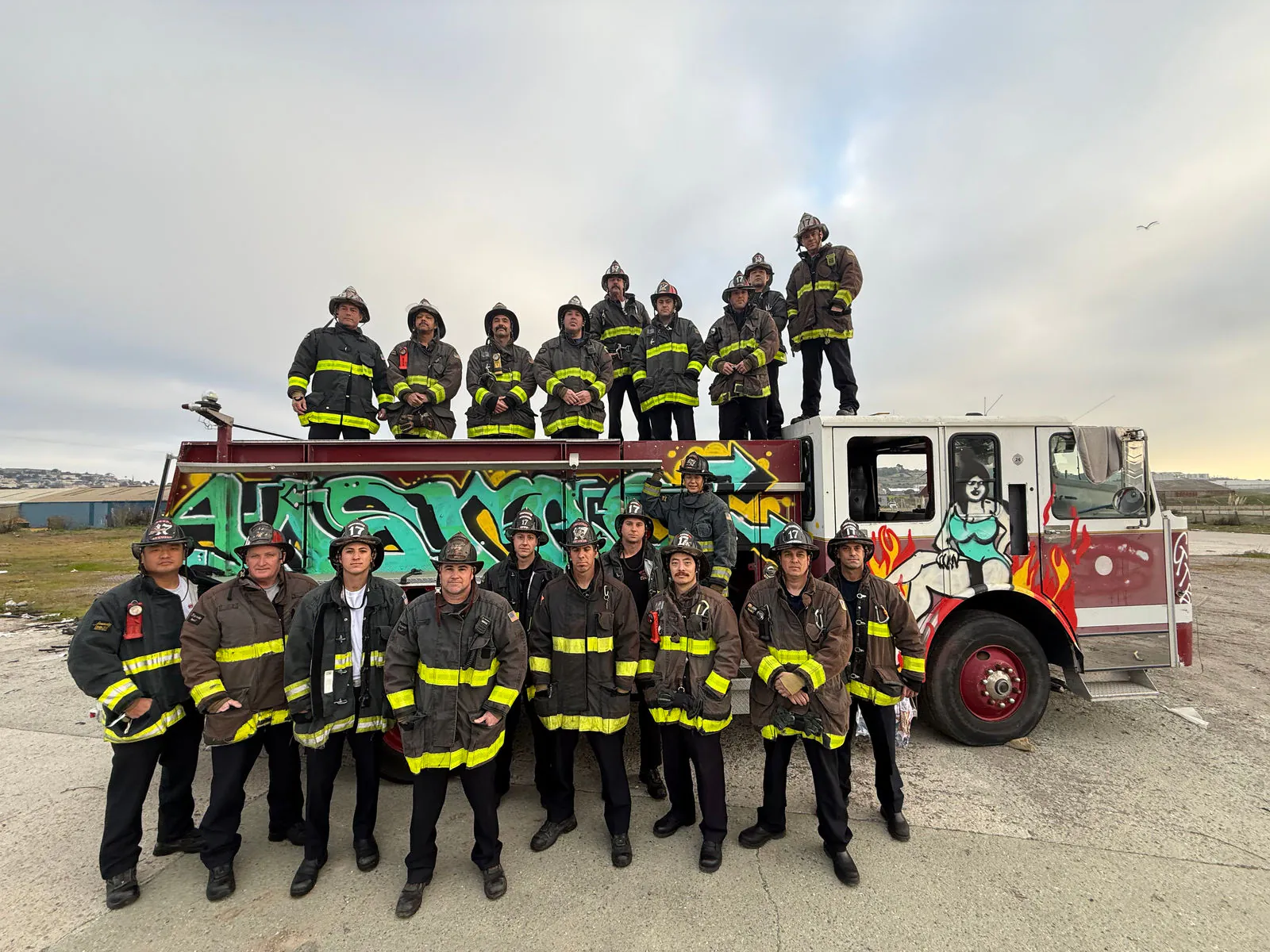 A full company in turnouts posed on and around their engine at the coast