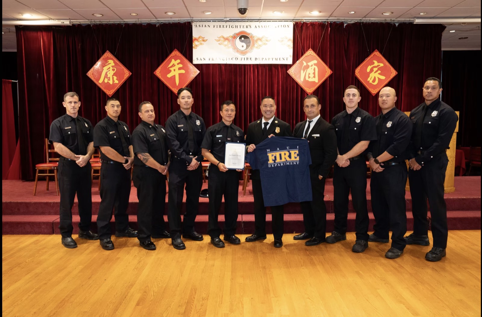Members on stage in dress uniform receiving a department award